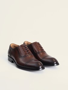 El par de zapatos oxford café con picado PuroEgo en vista de tres cuartos